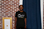 Lowkey Logo T worn by model against brick wall